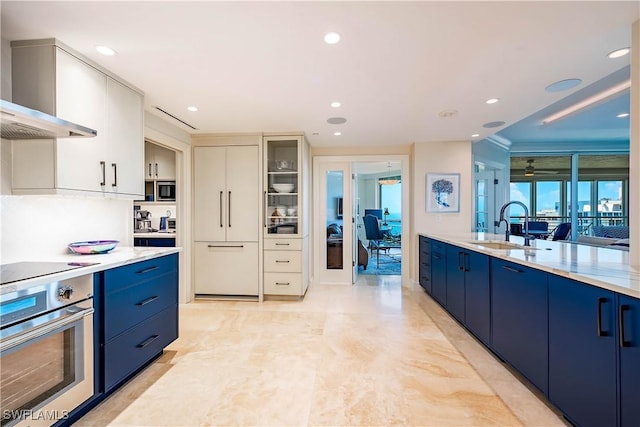 4021 Gulf Shore Blvd N Unit 1704, Naples, FL 34103 - kitchen featuring appliances with stainless steel finishes, wall chimney range hood, blue cabinetry, a sink, and recessed lighting