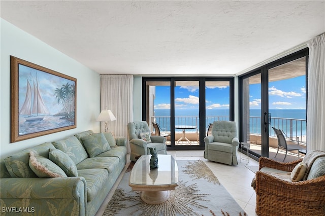 300 S Collier Blvd Unit 2304, Marco Island, FL 34145 - living area featuring a water view, expansive windows, light tile patterned flooring, a textured ceiling, and plenty of natural light