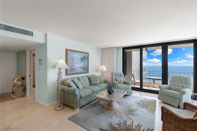 300 S Collier Blvd Unit 2304, Marco Island, FL 34145 - living room with light tile patterned flooring, a wall of windows, and a water view
