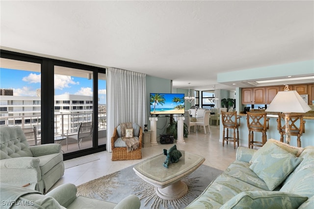 300 S Collier Blvd Unit 2304, Marco Island, FL 34145 - living area with light tile patterned floors, healthy amount of natural light, a wall of windows, and a chandelier