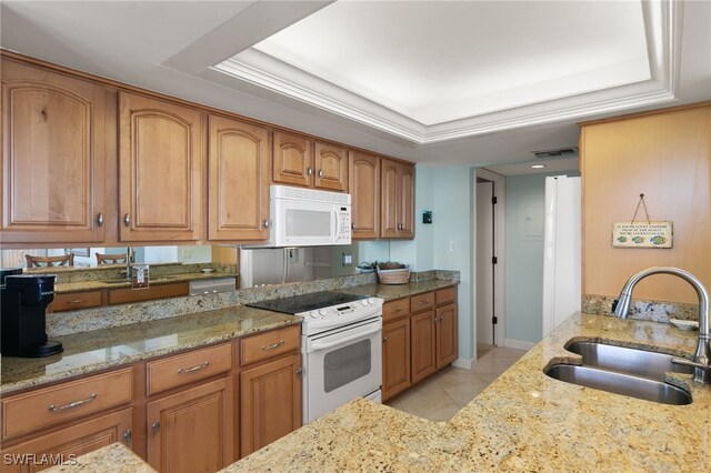 300 S Collier Blvd Unit 2304, Marco Island, FL 34145 - kitchen with white appliances, a sink, light stone counters, and brown cabinets
