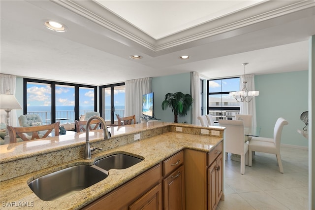 300 S Collier Blvd Unit 2304, Marco Island, FL 34145 - kitchen featuring brown cabinetry, a sink, light stone countertops, a chandelier, and pendant lighting