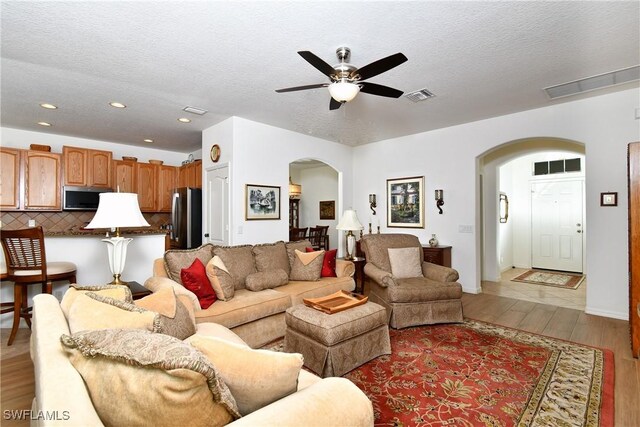 2842 Via Piazza Loop, Fort Myers, FL 33905 - living room featuring arched walkways, light wood-style flooring, ceiling fan, a textured ceiling, and recessed lighting