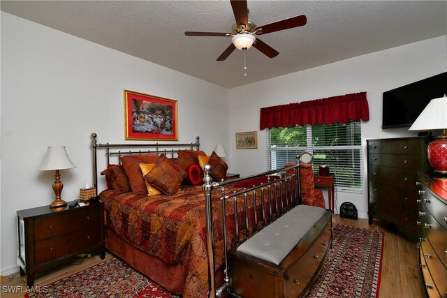 2842 Via Piazza Loop, Fort Myers, FL 33905 - bedroom with wood finished floors, ceiling fan, and a textured ceiling