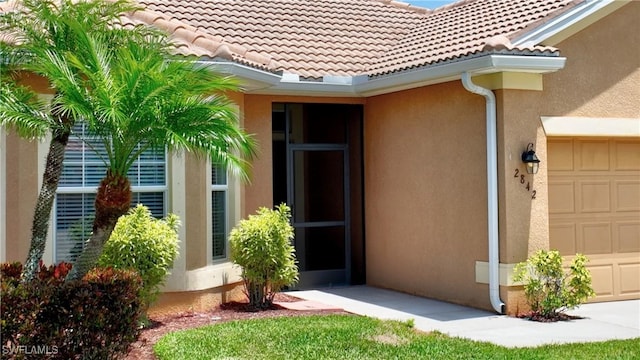 2842 Via Piazza Loop, Fort Myers, FL 33905 - doorway to property featuring an attached garage, stucco siding, and a tiled roof