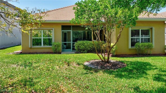 2842 Via Piazza Loop, Fort Myers, FL 33905 - back of house with stucco siding, a tiled roof, and a yard