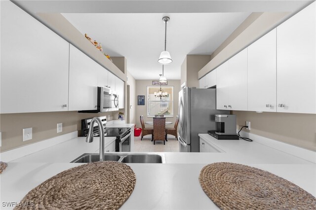 21360 Lancaster Run Unit 1514, Estero, FL 33928 - kitchen with appliances with stainless steel finishes, hanging light fixtures, a chandelier, white cabinetry, and light countertops