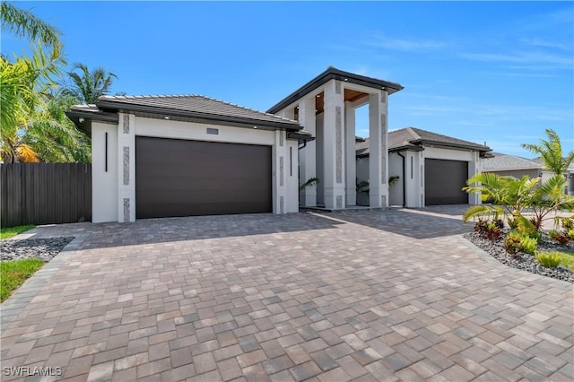 13 NW 14th Ave, Cape Coral, FL 33993 - view of front of house with a garage, decorative driveway, fence, and stucco siding