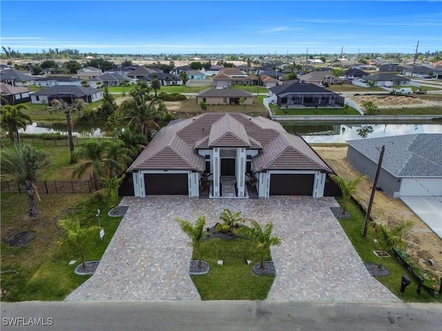 13 NW 14th Ave, Cape Coral, FL 33993 - view of front of house featuring an attached garage, a tile roof, a residential view, and a water view