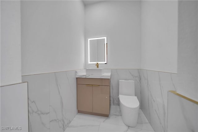 13 NW 14th Ave, Cape Coral, FL 33993 - bathroom with marble finish flooring, a wainscoted wall, vanity, toilet, and tile walls
