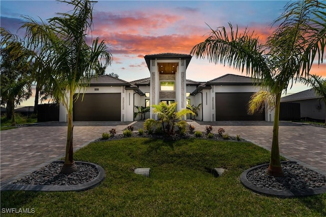 13 NW 14th Ave, Cape Coral, FL 33993 - view of front of house featuring a garage, decorative driveway, stucco siding, and a yard