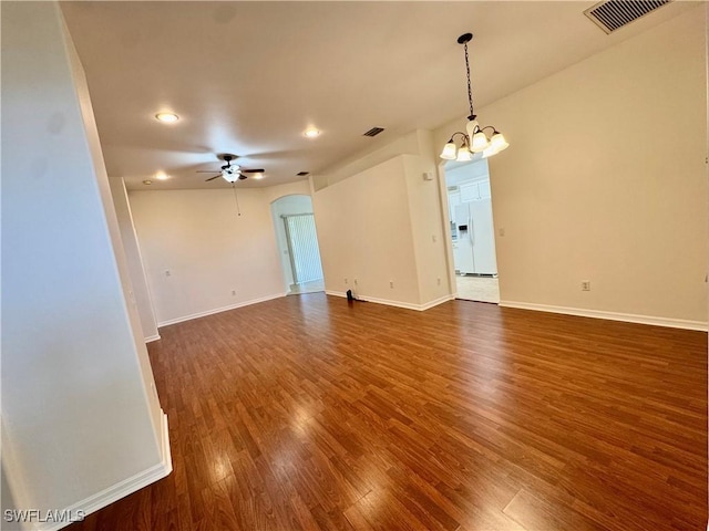 12635 Stone Tower Loop, Fort Myers, FL 33913 - empty room with dark wood-type flooring, a chandelier, ceiling fan, arched walkways, and baseboards
