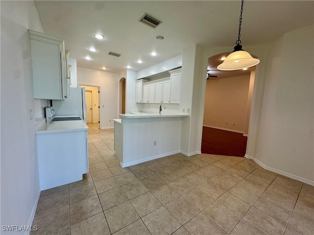 12635 Stone Tower Loop, Fort Myers, FL 33913 - kitchen featuring arched walkways, light tile patterned flooring, stove, freestanding refrigerator, and recessed lighting