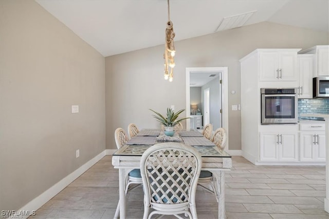 5748 Linden Ln, Bokeelia, FL 33922 - dining room featuring vaulted ceiling, light wood-style floors, and baseboards