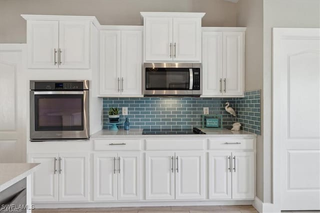 5748 Linden Ln, Bokeelia, FL 33922 - kitchen featuring stainless steel appliances, white cabinetry, light countertops, and decorative backsplash