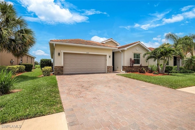 3147 Walnut Grove Ln, Alva, FL 33920 - view of front facade featuring decorative driveway, stucco siding, stone siding, a front yard, and a garage