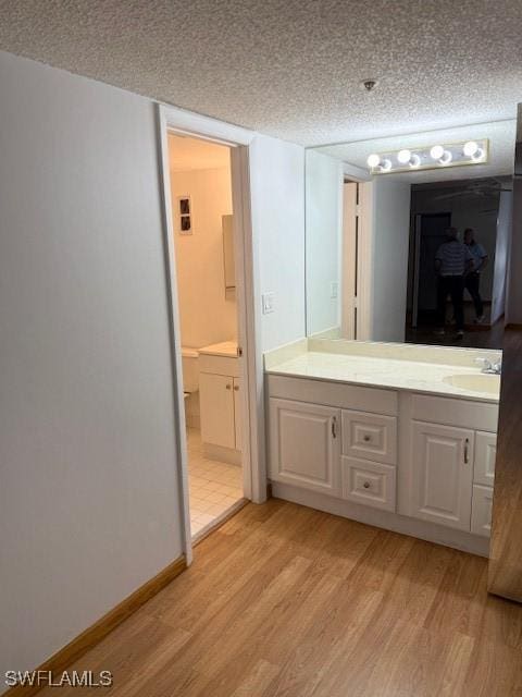 3910 Inverrary Blvd Unit 407-B, Lauderhill, FL 33319 - bathroom featuring wood finished floors, vanity, a textured ceiling, and baseboards