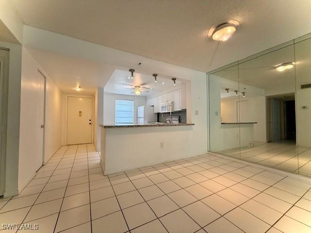 3910 Inverrary Blvd Unit 407-B, Lauderhill, FL 33319 - kitchen with white appliances, a ceiling fan, light tile patterned floors, and white cabinetry