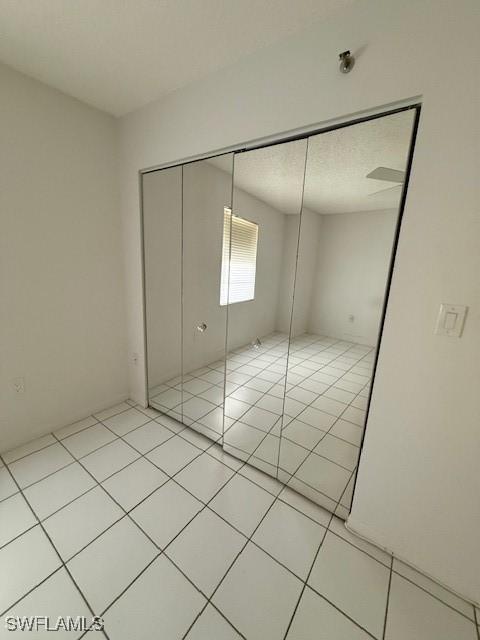 3910 Inverrary Blvd Unit 407-B, Lauderhill, FL 33319 - unfurnished bedroom featuring light tile patterned floors and a closet