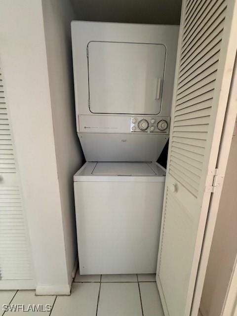 3910 Inverrary Blvd Unit 407-B, Lauderhill, FL 33319 - laundry room featuring estacked washer and dryer, light tile patterned floors, and baseboards