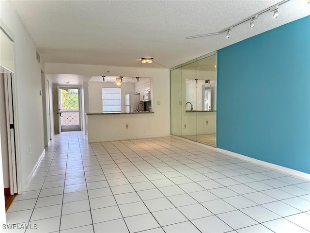 3910 Inverrary Blvd Unit 407-B, Lauderhill, FL 33319 - unfurnished living room with a textured ceiling, light tile patterned flooring, a sink, a ceiling fan, and baseboards
