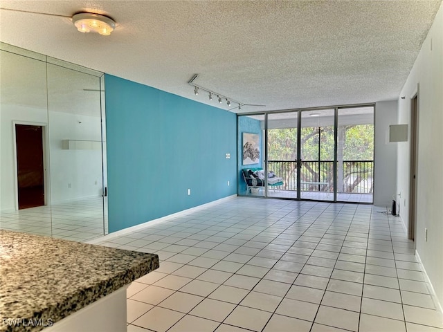 3910 Inverrary Blvd Unit 407-B, Lauderhill, FL 33319 - spare room featuring floor to ceiling windows, light tile patterned floors, track lighting, a textured ceiling, and baseboards