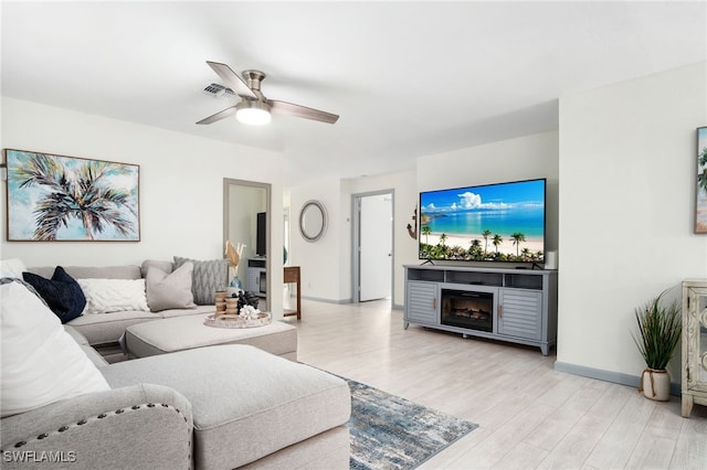 740 106th Ave N, Naples, FL 34108 - living room with light wood-style flooring, a ceiling fan, baseboards, and a fireplace