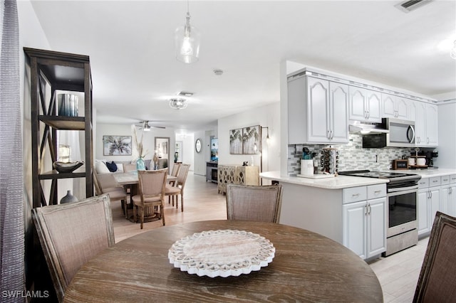 740 106th Ave N, Naples, FL 34108 - kitchen with stainless steel appliances, backsplash, under cabinet range hood, ceiling fan, and light countertops