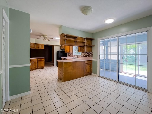 kitchen featuring a peninsula, open shelves, decorative backsplash, and plenty of natural light