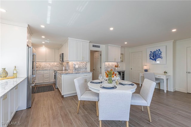 2100 Gulf Shore Blvd N Unit 118, Naples, FL 34102 - dining area with recessed lighting, light wood-style flooring, wine cooler, and ornamental molding