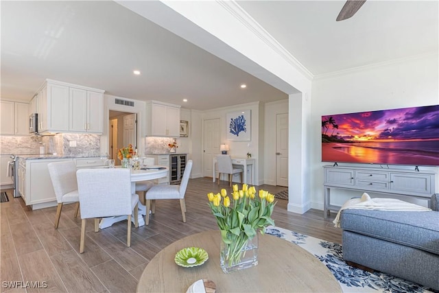 2100 Gulf Shore Blvd N Unit 118, Naples, FL 34102 - dining room featuring wine cooler, light wood-type flooring, recessed lighting, crown molding, and baseboards