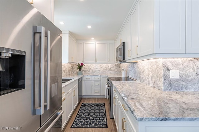 2100 Gulf Shore Blvd N Unit 118, Naples, FL 34102 - kitchen with appliances with stainless steel finishes, dark wood-style floors, white cabinetry, and recessed lighting