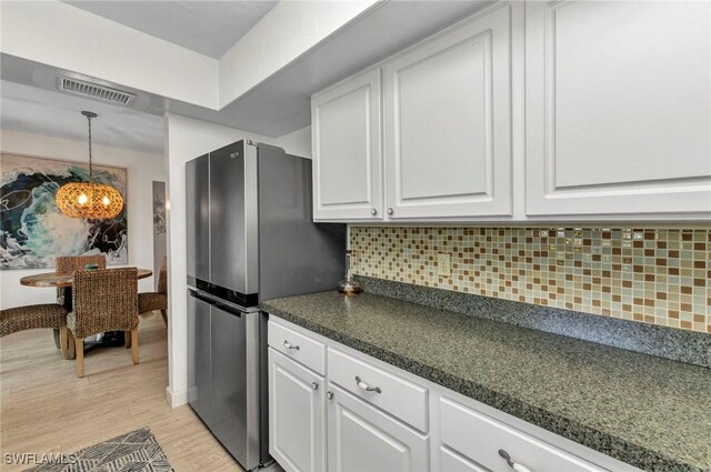125 Donna Ct, Punta Gorda, FL 33950 - kitchen with freestanding refrigerator, white cabinetry, dark countertops, and tasteful backsplash