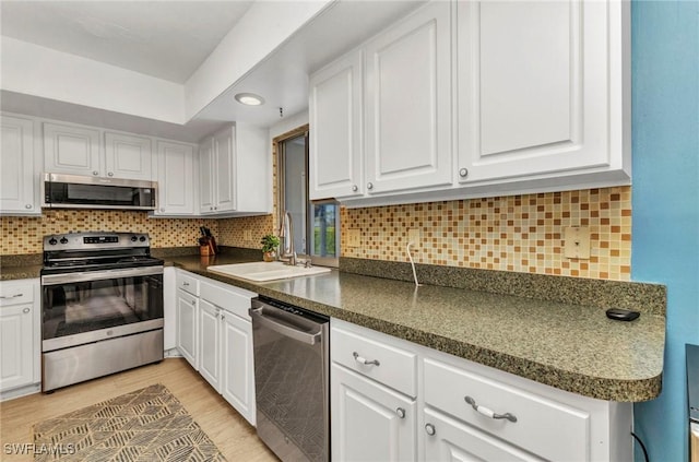 125 Donna Ct, Punta Gorda, FL 33950 - kitchen with stainless steel appliances, a sink, white cabinets, dark countertops, and recessed lighting