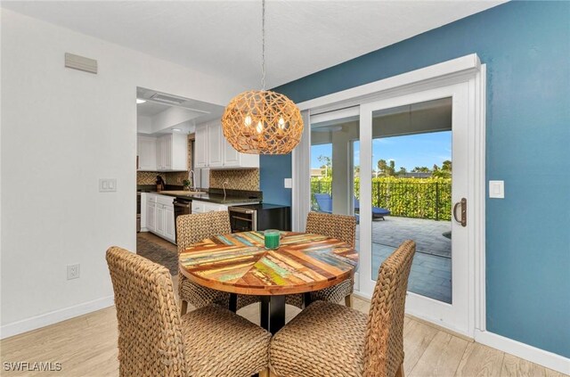 125 Donna Ct, Punta Gorda, FL 33950 - dining space featuring baseboards, light wood-type flooring, and a chandelier