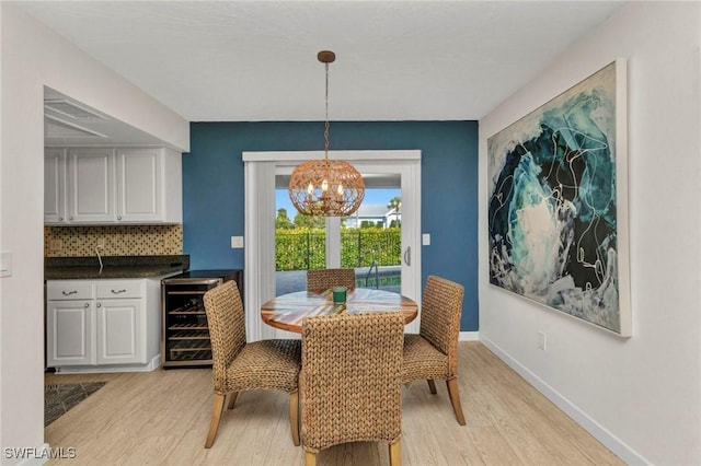 125 Donna Ct, Punta Gorda, FL 33950 - dining area featuring wine cooler, light wood-type flooring, a chandelier, and baseboards