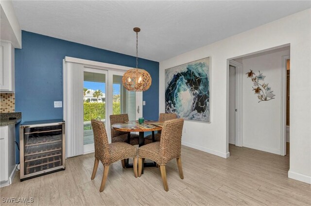 125 Donna Ct, Punta Gorda, FL 33950 - dining space featuring beverage cooler, a chandelier, light wood finished floors, and baseboards