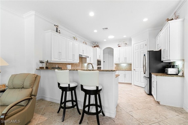 10986 Longwing Dr, Fort Myers, FL 33912 - kitchen featuring a peninsula, a breakfast bar area, backsplash, white cabinets, and recessed lighting