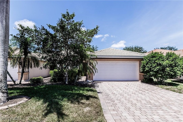 14183 Fall Creek Ct, Naples, FL 34114 - view of front of home with decorative driveway, a garage, stucco siding, and a tile roof