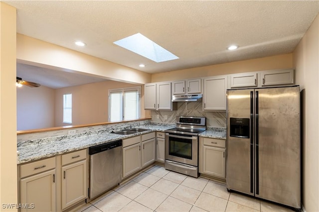 2022 Hunters Trace Cir, Middleburg, FL 32068 - kitchen featuring appliances with stainless steel finishes, under cabinet range hood, a skylight, a sink, and gray cabinetry