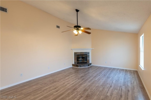 2022 Hunters Trace Cir, Middleburg, FL 32068 - unfurnished living room with wood finished floors, ceiling fan, a tile fireplace, lofted ceiling, and baseboards
