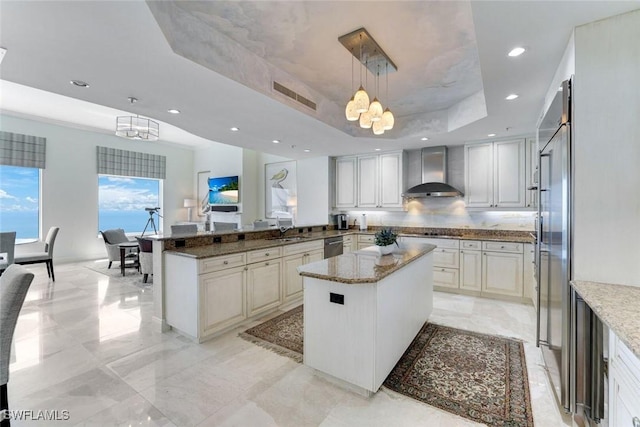 970 Cape Marco Dr Unit 2105, Marco Island, FL 34145 - kitchen featuring wall chimney exhaust hood, a chandelier, a tray ceiling, light stone countertops, and recessed lighting