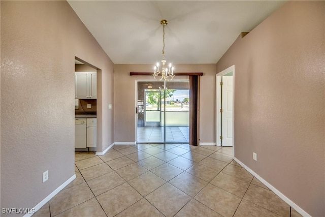 1601 SW 19th St, Cape Coral, FL 33991 - unfurnished dining area featuring a chandelier, light tile patterned floors, a textured wall, and baseboards