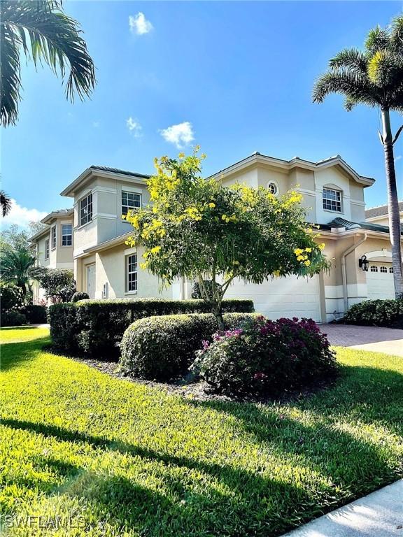 650 Vintage Reserve Cir Unit 5C, Naples, FL 34119 - view of front facade featuring stucco siding, a front yard, a garage, and driveway
