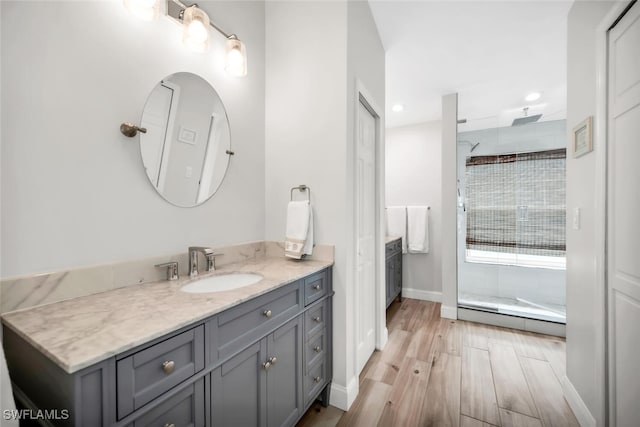 28996 Seton Ct, Bonita Springs, FL 34134 - bathroom with a baseboard radiator, vanity, tiled shower, recessed lighting, and wood finished floors