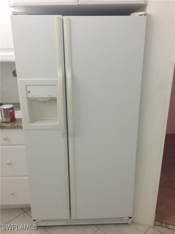 3760 Inverrary Dr Unit 1W, Lauderhill, FL 33319 - detailed view of white fridge with ice dispenser, white cabinetry, tasteful backsplash, and stone counters
