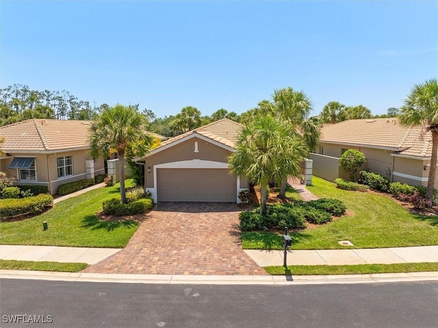 9327 Trieste Dr, Fort Myers, FL 33913 - view of front of home featuring a front yard, decorative driveway, an attached garage, and stucco siding