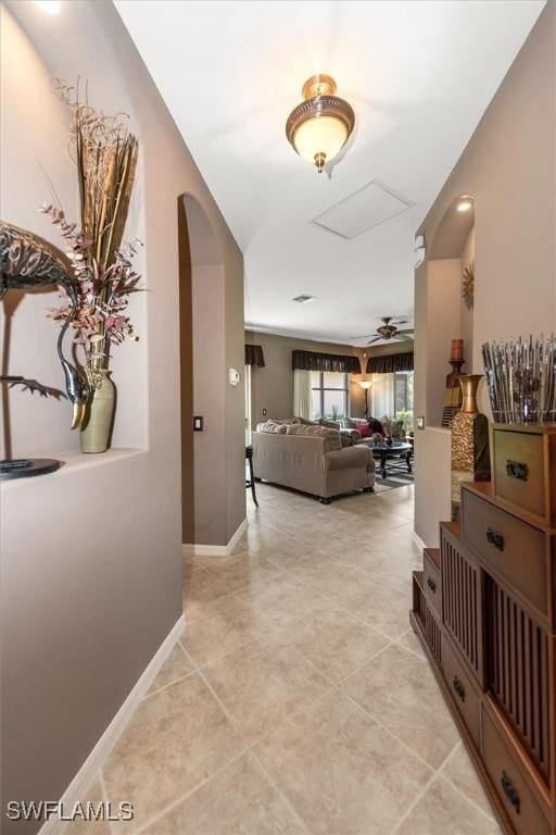 9327 Trieste Dr, Fort Myers, FL 33913 - hallway featuring arched walkways, light tile patterned floors, and attic access