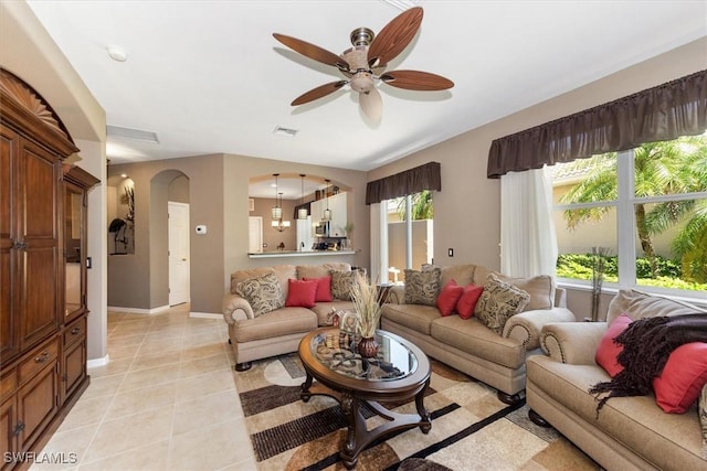 9327 Trieste Dr, Fort Myers, FL 33913 - living area featuring arched walkways, ceiling fan, light tile patterned floors, and baseboards