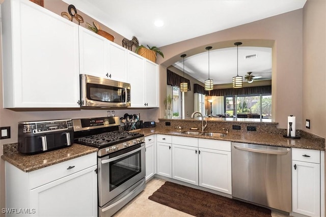 9327 Trieste Dr, Fort Myers, FL 33913 - kitchen with stainless steel appliances, a sink, dark stone countertops, white cabinetry, and recessed lighting